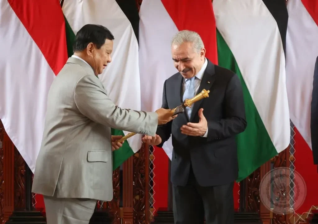 Prabowo memberikan kenang-kenangan kepada perwakilan Palestina di depan bendera Indonesia dan Palestina.