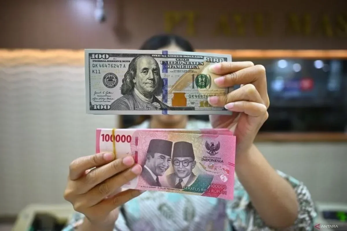 Tangan memegang uang Dolar AS dan Rupiah, tunjukkan pelemahan nilai tukar.