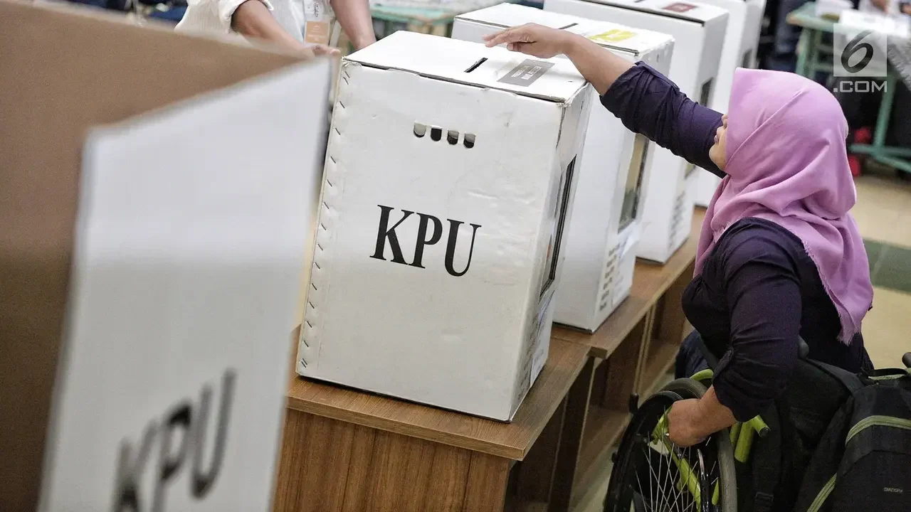 Petugas KPU memasukkan surat suara ke dalam kotak suara saat pemilu.