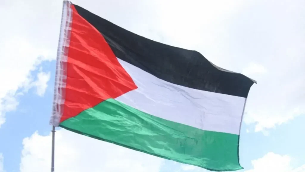 Bendera Palestina berkibar gagah dengan latar belakang langit biru berawan.
