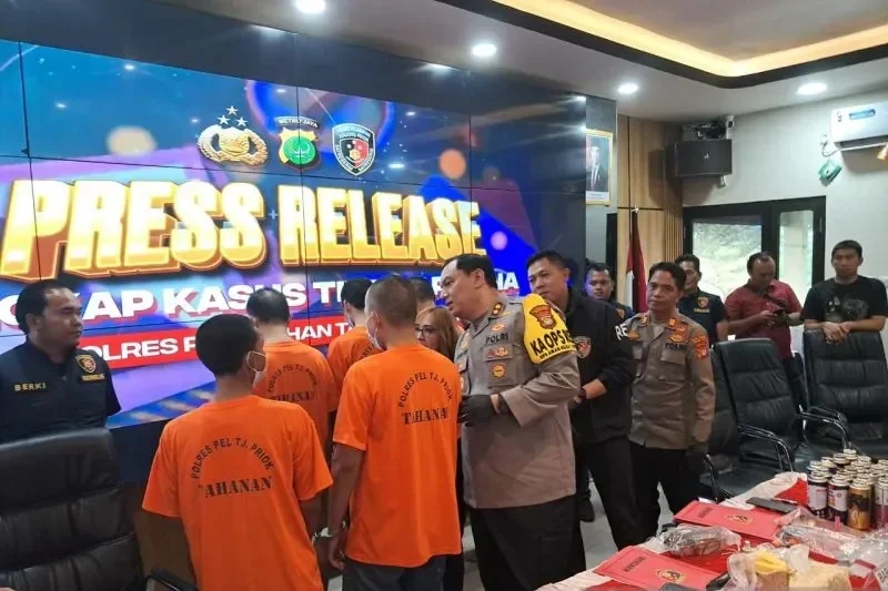 Tersangka kriminal digiring polisi dalam acara rilis pers di kantor kepolisian.