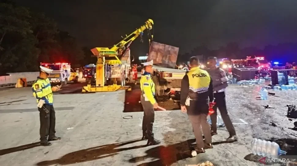 Petugas kepolisian menangani kecelakaan truk di Gerbang Tol Ciawi 2 pada dini hari.
