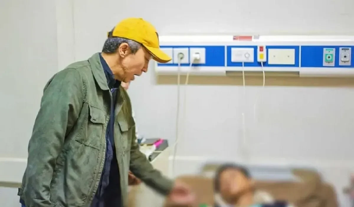 Seorang pria mengunjungi siswa yang dirawat di rumah sakit usai keracunan massal.