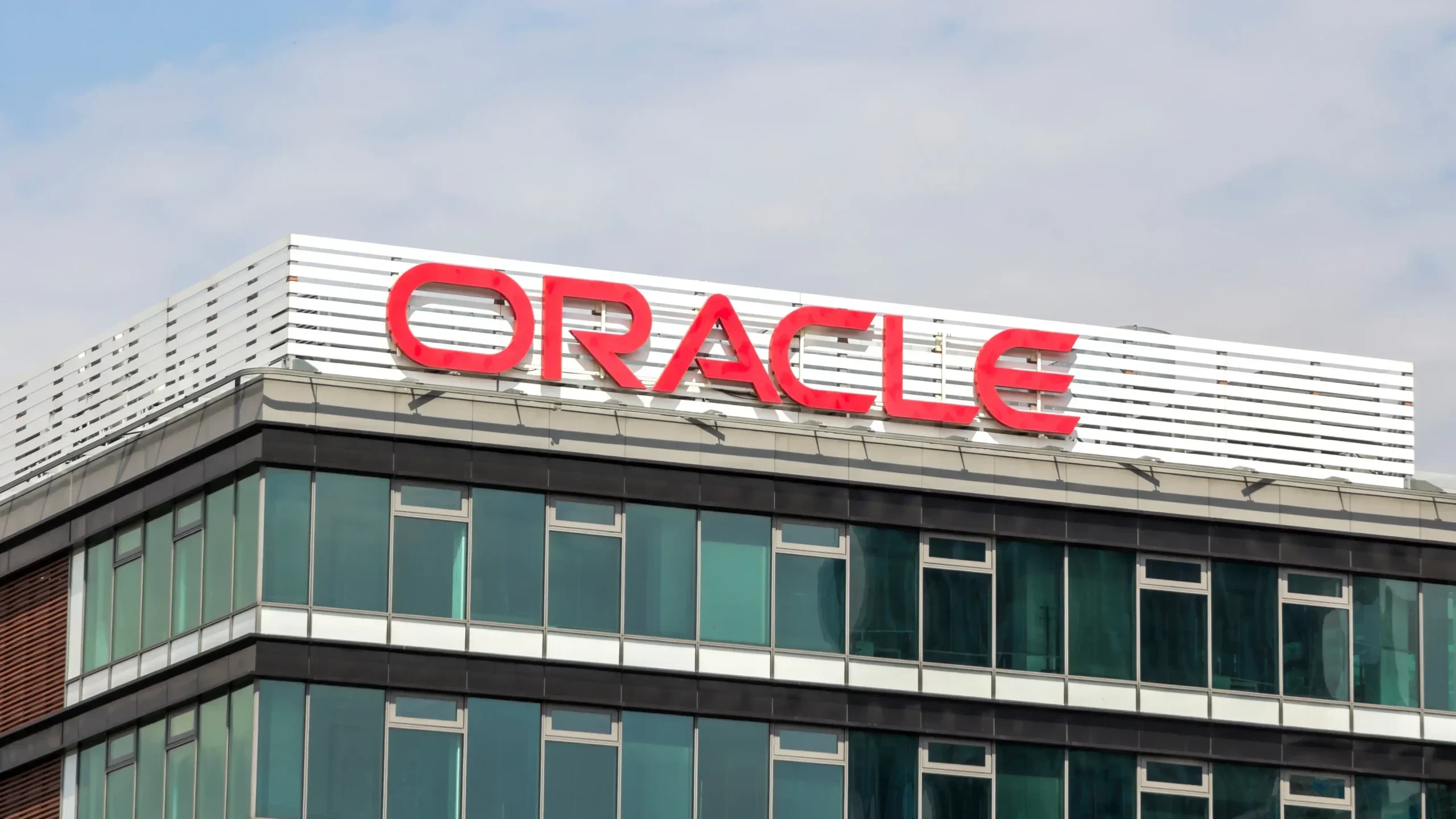 Gedung Oracle dengan logo merah menyala di atasnya.