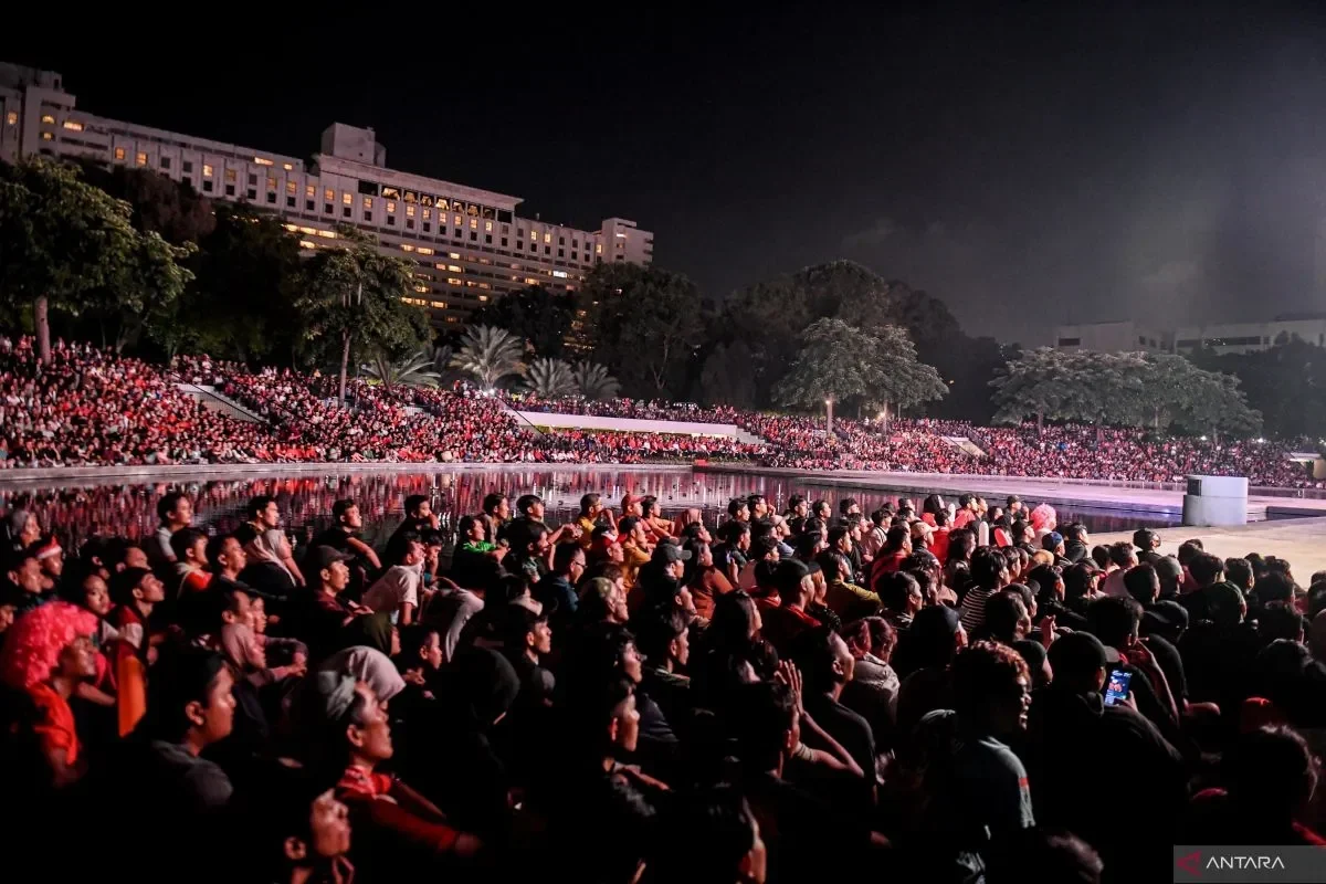 Penonton memadati area terbuka di malam hari, menyoroti antusiasme publik.