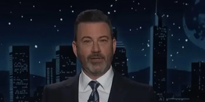 Jimmy Kimmel tampil di acara bincang-bincangnya dengan latar belakang kota malam hari.