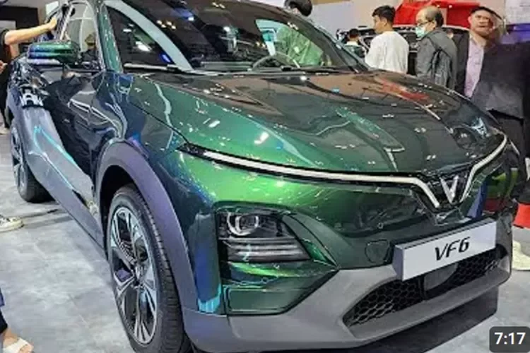 Mobil listrik VinFast VF6 berwarna hijau berkilau di pameran otomotif.
