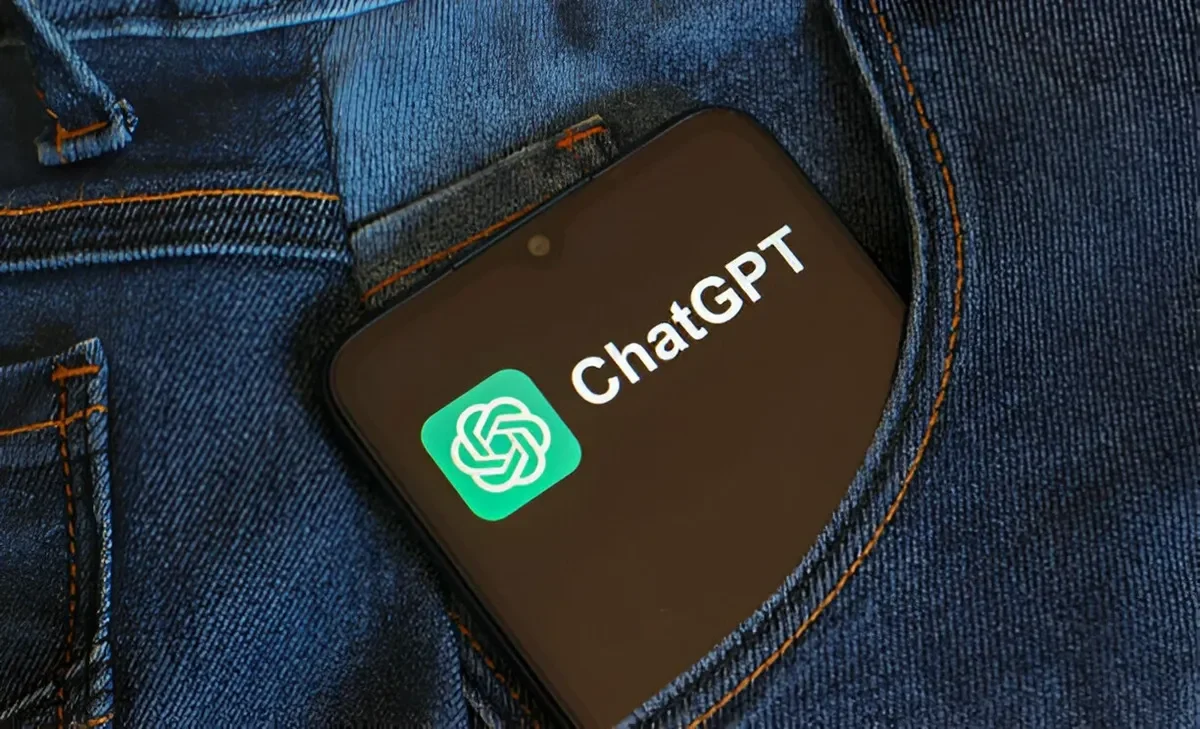 Layar ponsel menampilkan logo dan nama ChatGPT tersimpan di saku celana jeans.