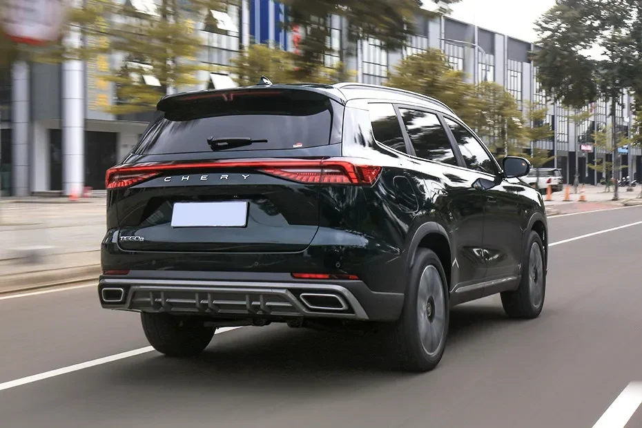Mobil Chery Tiggo 8 CSH warna hitam melaju di jalan raya perkotaan.