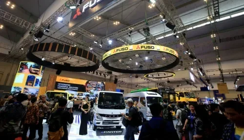 Suasana pameran otomotif dengan berbagai merek kendaraan dan pengunjung yang ramai.