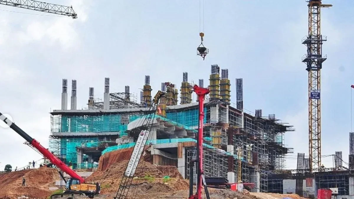 Lokasi konstruksi dengan alat berat dan bangunan yang sedang dibangun.